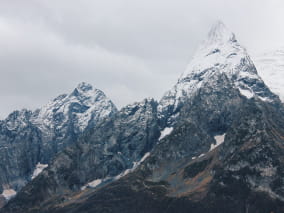 Заснеженные пики гор на фоне облаков.